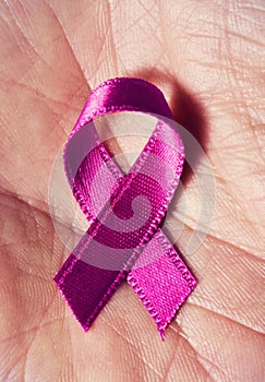 A pink ribbon in the hand of a man