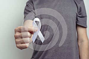 Pink ribbon over palm. White background