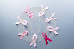 Pink ribbon on pastel paper background for supporting breast cancer awareness month campaign