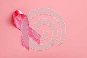 Pink ribbon on pink background. Breast cancer awareness concept, copy space