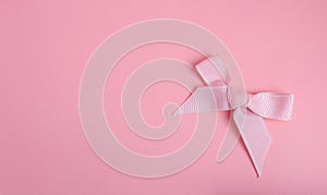 Pink ribbon on pink paper backgroun