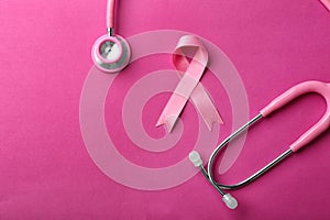 Pink ribbon and stethoscope on color background. Breast cancer awareness concept