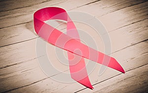 Pink ribbon on a wooden background as a symbol of breast cancer, a sign of the fight against cancer