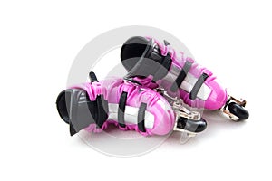 Pink rollerblades laying on their side
