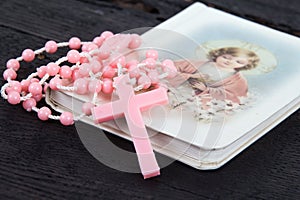 Pink rosary over a religious book