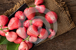 Pink rose apple on wood table