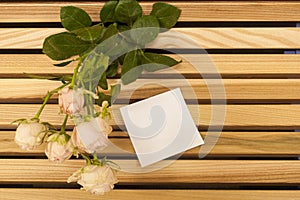 Pink rose bouquet closup and sticker note on a wooden bench