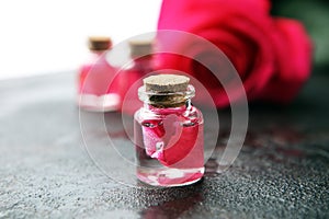 Pink rose flower and glass of bottle essential oil. spa and aromatherapy cosmetic concept