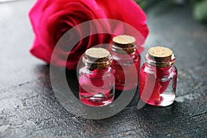 Pink rose flower and glass of bottle essential oil. spa and aromatherapy cosmetic concept