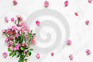 Pink rose flowers bouquet with frame made of flower buds with copy space on white marble table. flat lay. top view