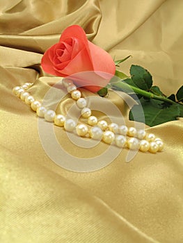 Pink rose and pearls on gold satin