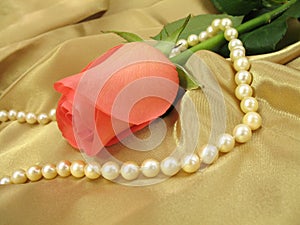 Pink rose and pearls on gold satin