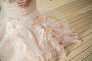 Pink rose petals speckle the pristine white chiffon trim of this