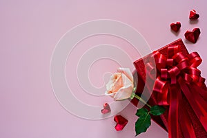 Pink rose in red gift box with love shape on pink background