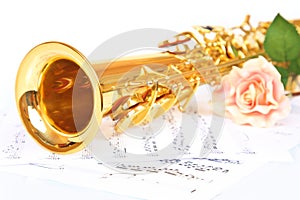 Pink rose, saxophone and music sheet