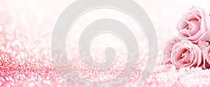 Pink roses bouquet and pearls on abstract blur pastel background. Wedding flowers and bright bokeh glitter backdrop