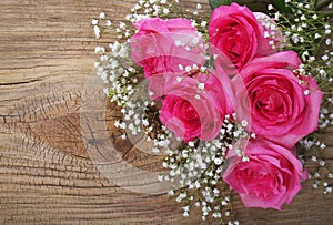 Pink Roses and Gypsophila on Wooden Background