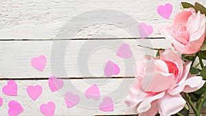 Pink roses and hearts on a white wooden table. Copy space for text. Template for March 8, Mother`s Day, Valentine`s Day. Banner