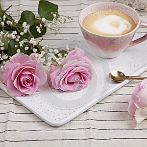 Pink roses on marble plate with pink coffee cup photo