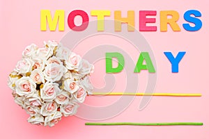 Pink roses with for Mothers day on background of text, flat ray. Copy space. Top view.