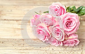 Pink roses on the old wooden desk table