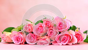 Pink roses on pink wood table, Mother`s Day background closeup.