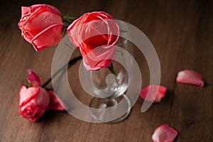 pink roses put in champagne glass on dark color wooden table