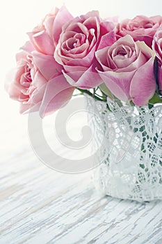 Pink roses in a white lace vase