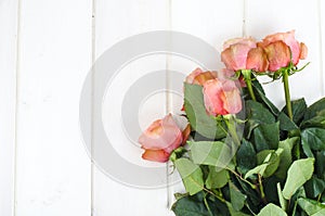 Pink roses on white wooden table