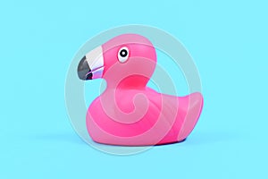 Pink rubber duck flamingos on blue background with copy space