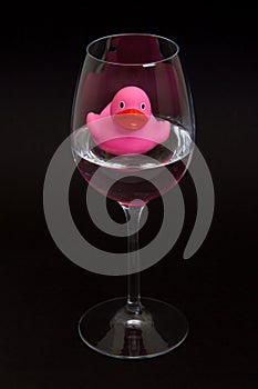 Pink rubber duck in a wineglass