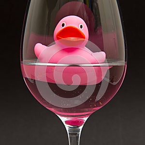Pink rubber duck in a wineglass