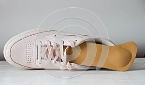 Pink running shoe with orthopedic insoles. White background