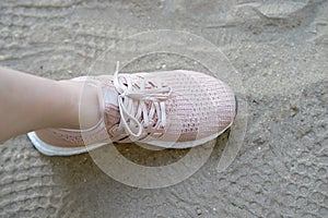 Pink runnung shoes one side stamp on sand with shoes prints
