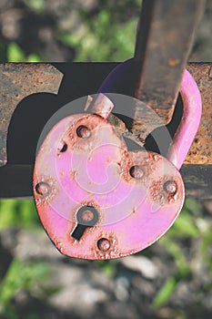 Rusty heart-shaped padlock on bridge