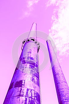 Pink rusty pipes emitting radiation produce smog into the bright poisonous purple sky, the concept of pollution and environmental