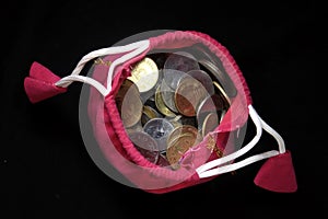 Pink Sack with Indian currency coins. Coin in cotton sack with money. Stacking coin in sack on black background