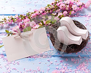 Pink sakura flowers, empty tag and two white wooden decorative