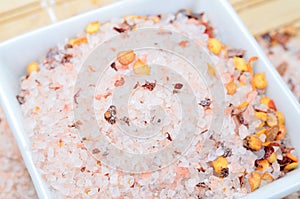 Pink salt with chili seed on table