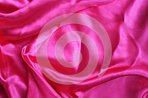 Pink satin background. Silk fabric with pleats. Satin, silk or satin create a beautiful drapery.
