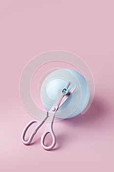 Pink Scissors Cutting Blue Balloon On Pink Background