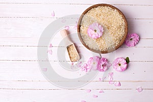 Pink sea salt in bowl and pink flowers