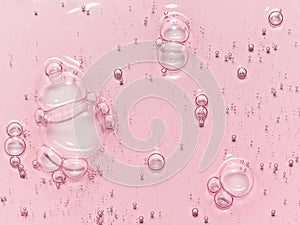 Pink serum oil texture with bubbles background