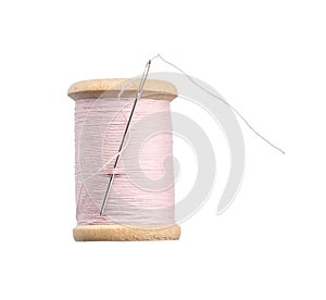 Pink sewing thread with needle isolated on white