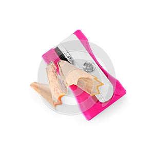 Pink sharpener with pencil shavings on white background, top view