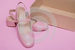 pink shoes with empty shoebox on pink background