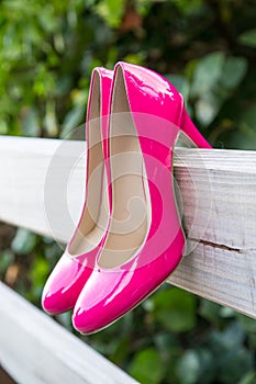 Pink shoes on fence