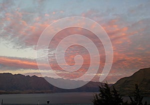 Pink sky while sunrise in Queenstown, alpine mountains and the lake Wakatipu