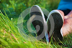 Pink sneakers on girl legs on grass