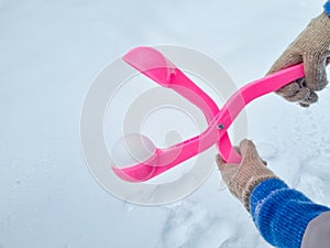 pink snowball maker make balls out of snow.